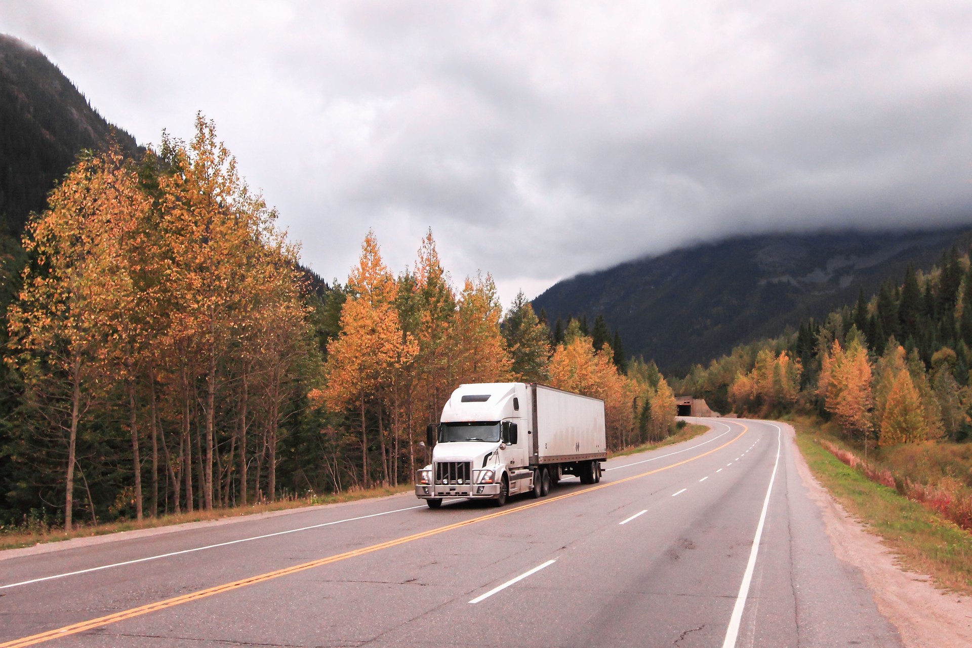 Semi truck trailer on the road in the fall